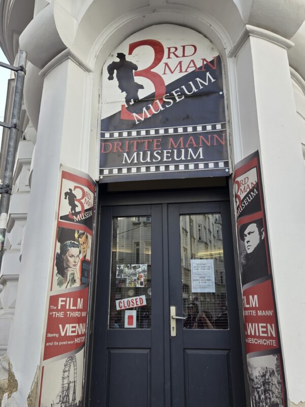 Entrance to the 3rd Man Museum with a large circular sign above the door and red/white film posters on the surrounding columns.