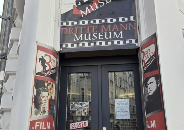 Entrance to the 3rd Man Museum with a large circular sign above the door and red/white film posters on the surrounding columns.