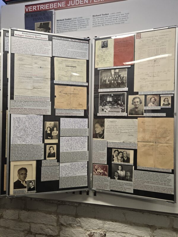 Exhibit boards with historical documents and photos about Jewish refugees on a two-panel display.