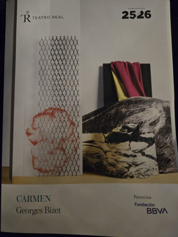 Collage-style page with a chain-link fence pattern, a red flower motif, and a rock with a magenta and yellow cloth draped over a black panel; Teatro Real logo and '2526' appear at the top; 'Carmen Georges Bizet' text at bottom left.